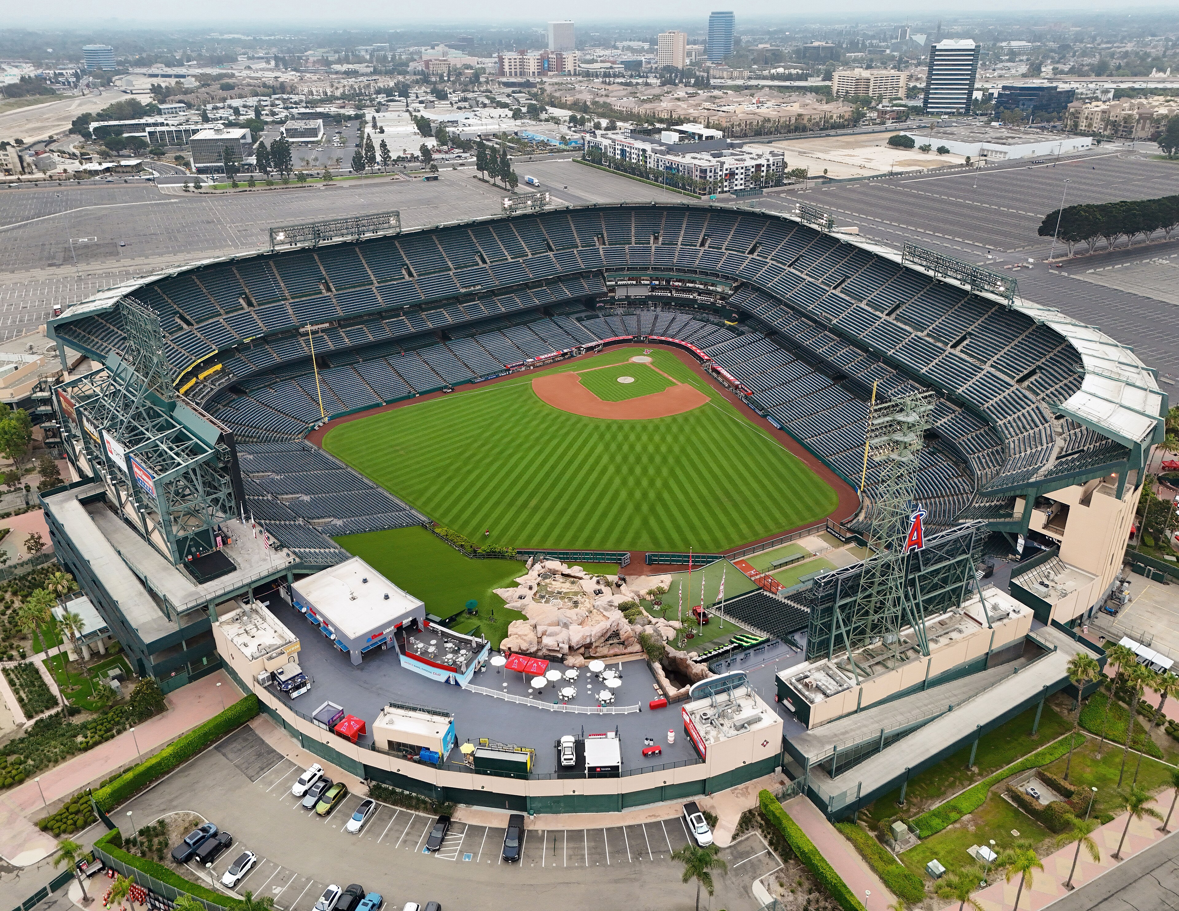 Aerial photograph of the actual Angel Stadium in Anaheim in August 2025, showing the field, seating bowl, rock pile and surrounding neighborhood.